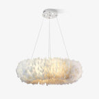 A Clérachic feather ring pendant lit warm white on three cables from a white canopy, on a pale grey background.