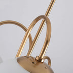Close-up of the Clérachic chandelier gooseneck arm looping into a globe brass cap, highlighting the gold metal joinery.