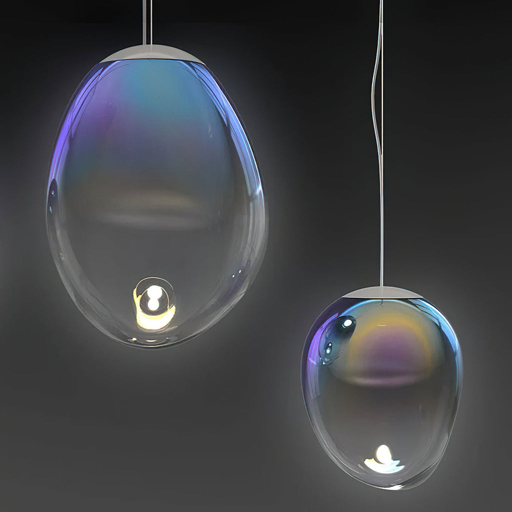 Two Clérachic glass pendants glow against a dark backdrop, their clear shades showing blue, purple and gold colour near the top.