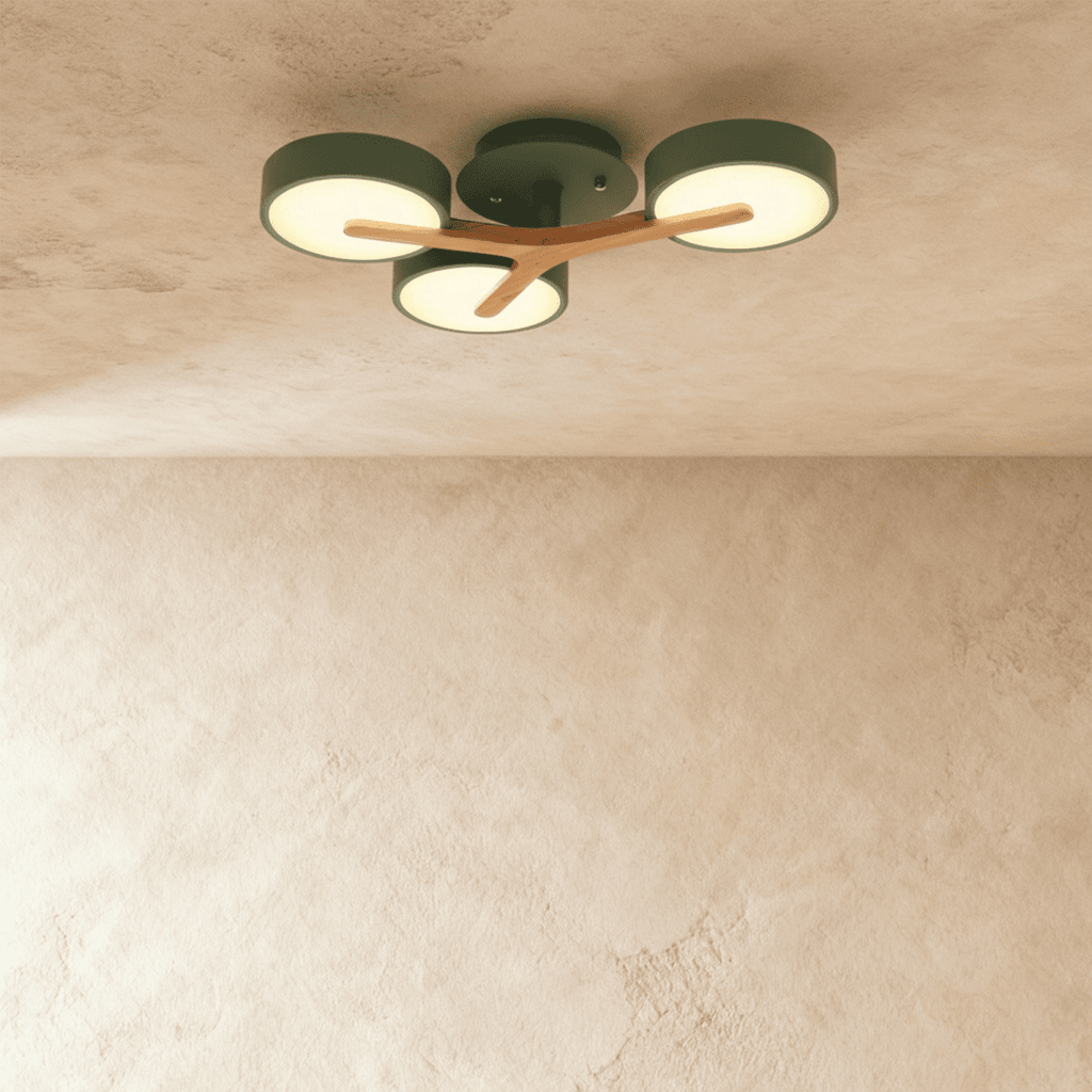 Clérachic's ceiling light in forest green, three round diffusers branching from a light wood cross arm overhead.