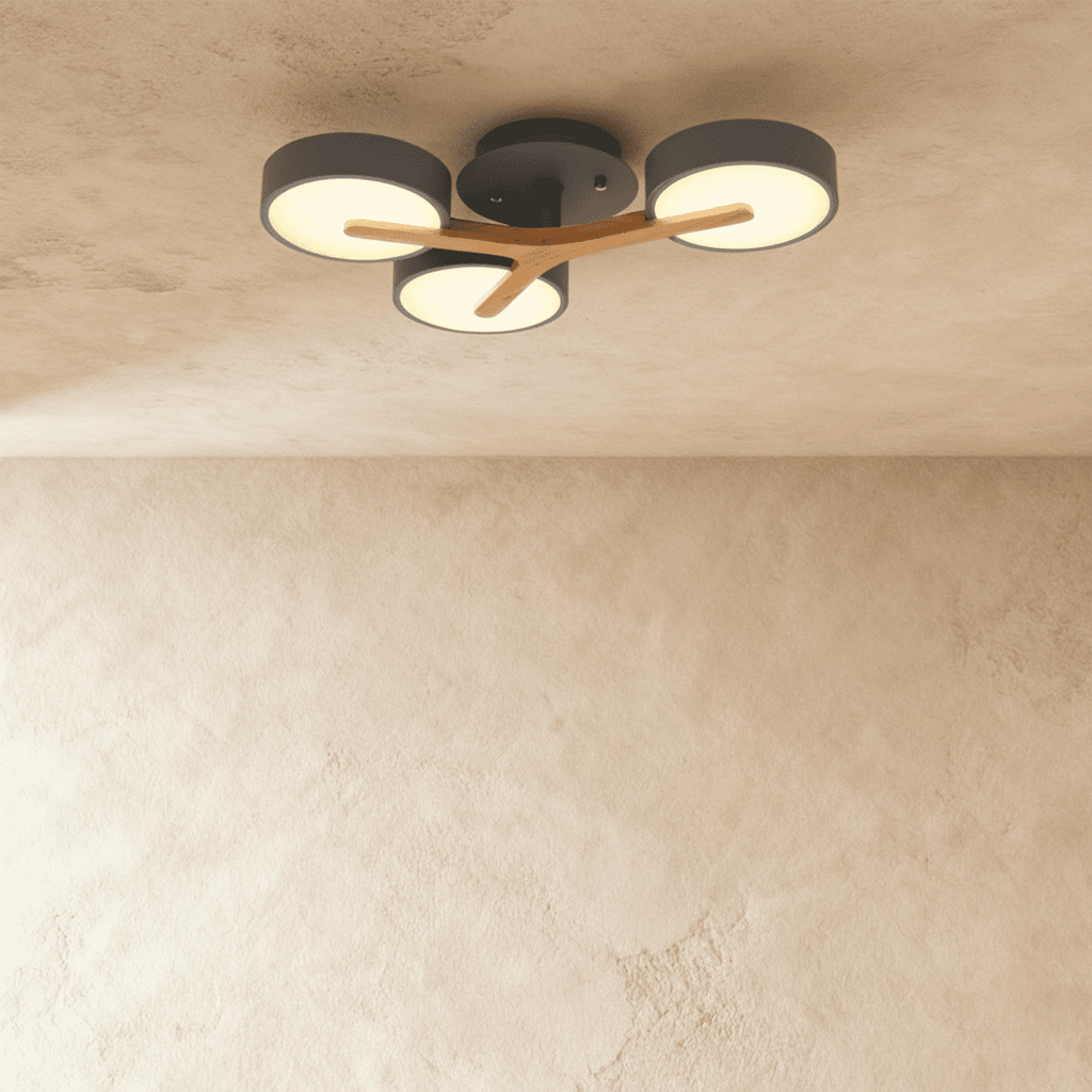 Clérachic's ceiling light in charcoal gray, three round shades mounted on a light wood cross arm overhead.