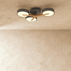 Clérachic's ceiling light in charcoal gray, three round shades mounted on a light wood cross arm overhead.