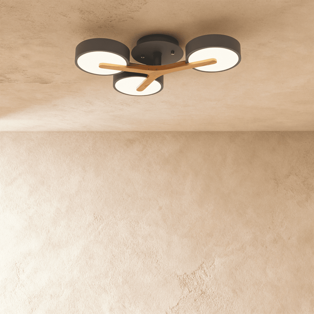 A closer view of the Clérachic ceiling light in gray, showing its three illuminated diffusers and wood arm.