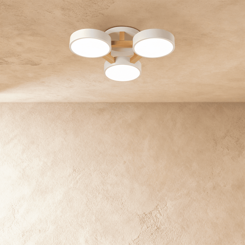 Clérachic's ceiling light in white, three drum shades set directly on a light wood cross bar overhead.
