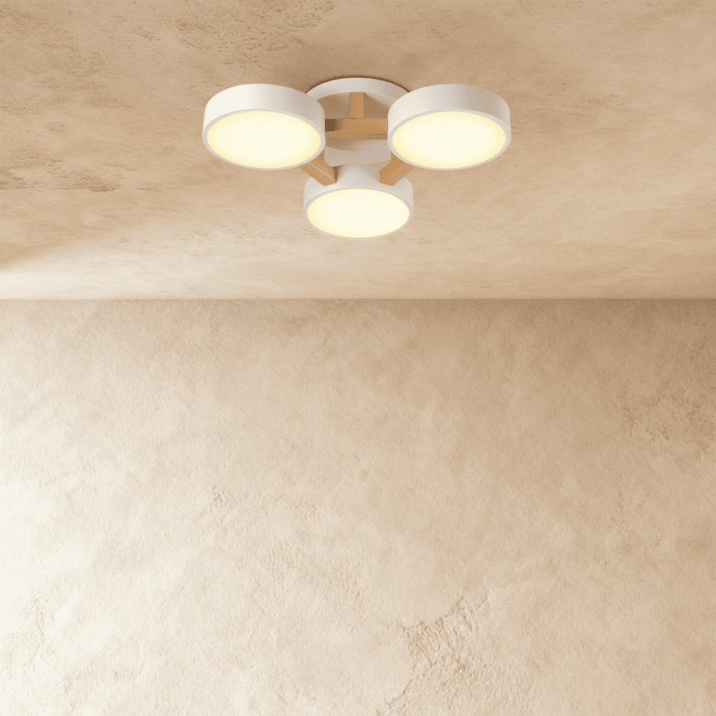 The Clérachic ceiling light in white, its three drum diffusers glowing warm against the ceiling above.