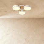 The Clérachic ceiling light in white, its three drum diffusers glowing warm against the ceiling above.