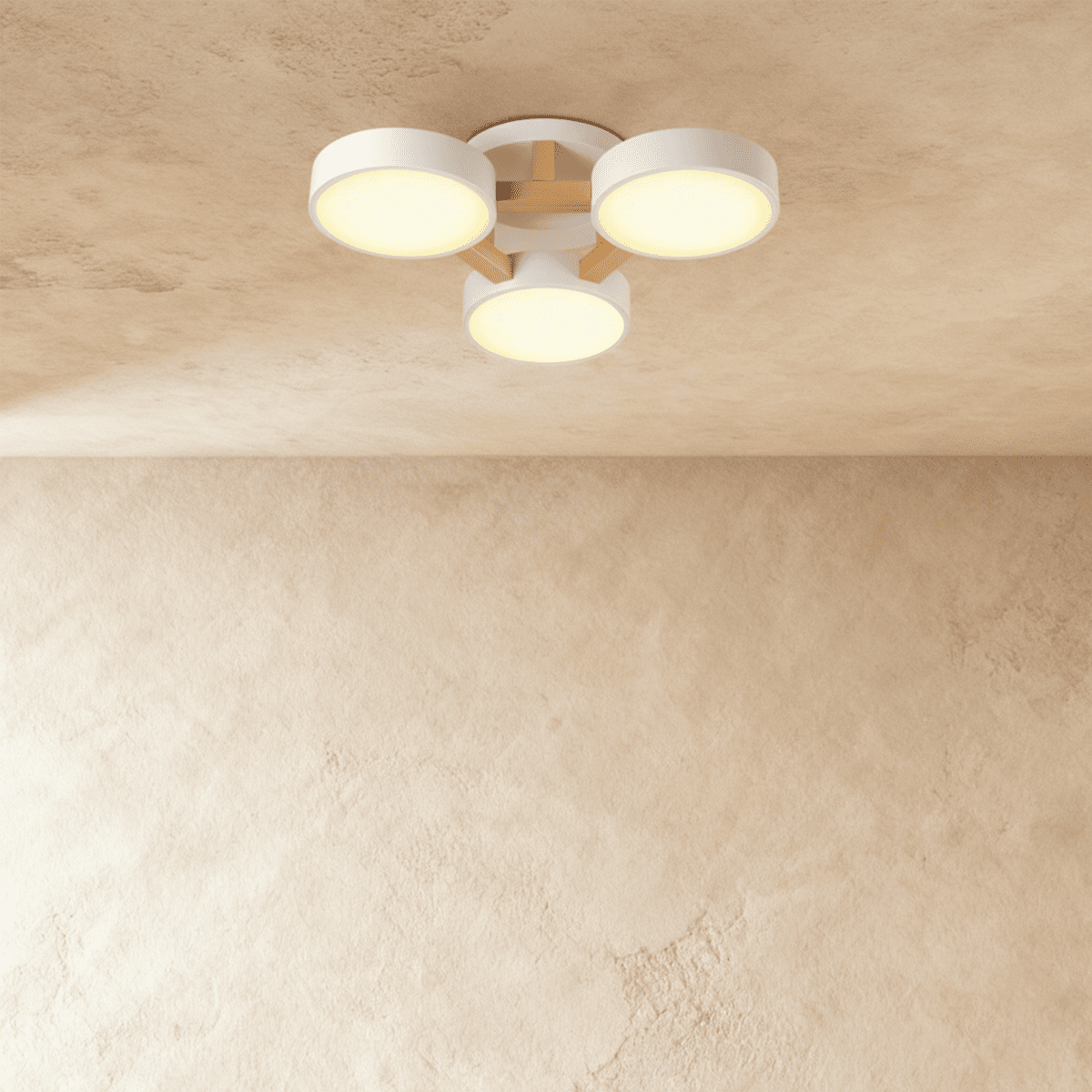The Clérachic ceiling light in white, its three drum diffusers glowing warm against the ceiling above.
