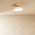 Clérachic's ceiling light in white, a single round diffuser on a light wood ceiling plate, semi-flush mount.