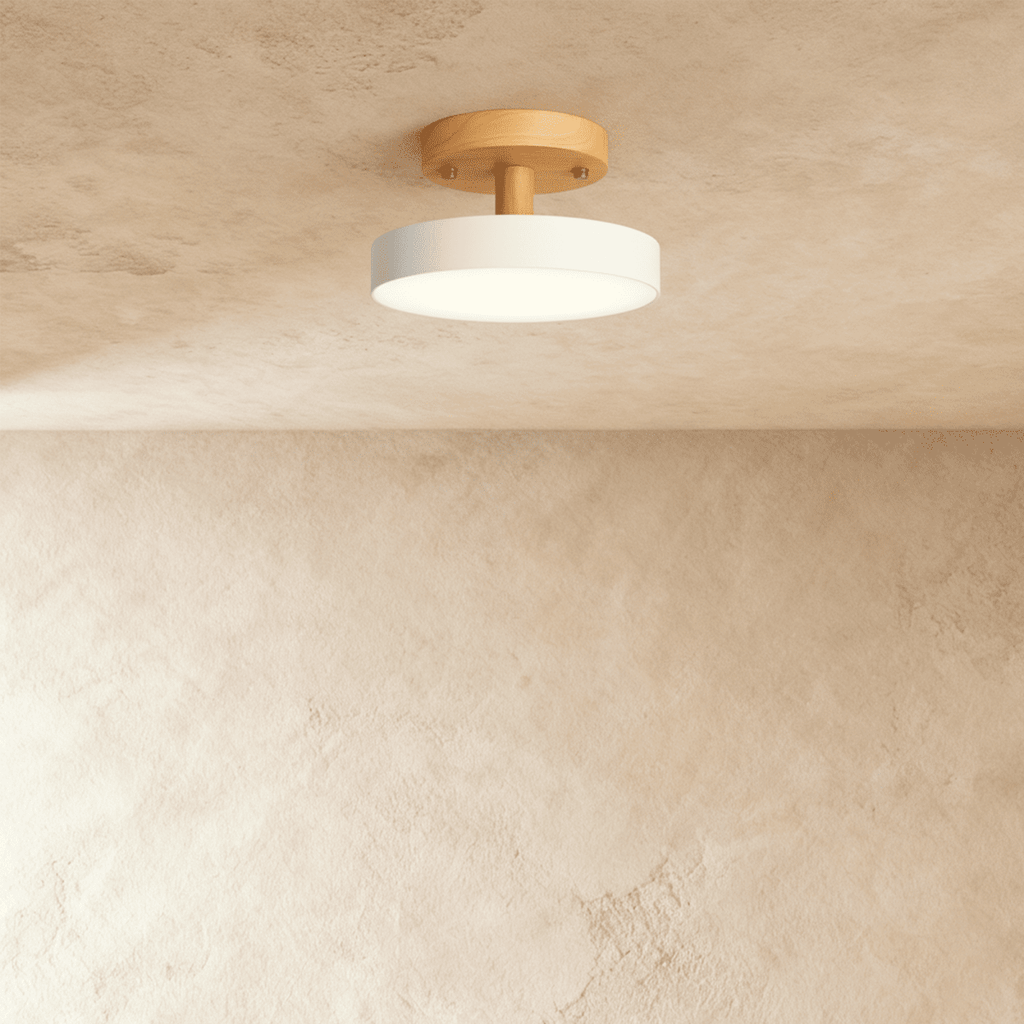 A closer angle of the Clérachic ceiling light in white, its single drum diffuser lit against the ceiling.