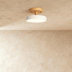 A closer angle of the Clérachic ceiling light in white, its single drum diffuser lit against the ceiling.