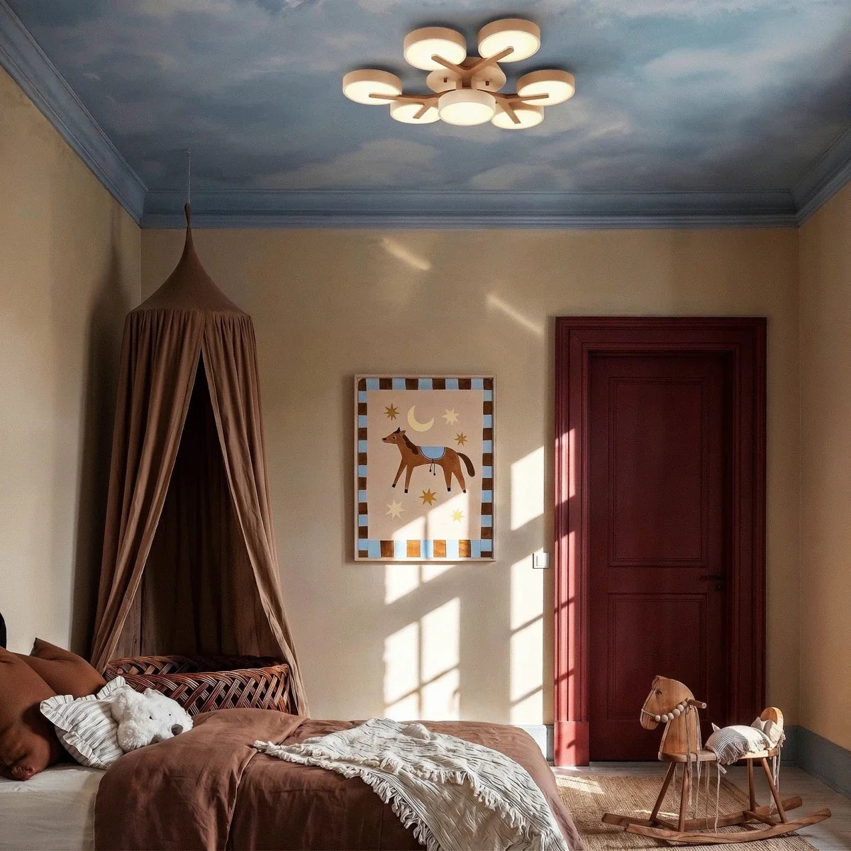 Clérachic's ceiling light in a light wood-toned finish, a branching cluster glowing above a child's bedroom.