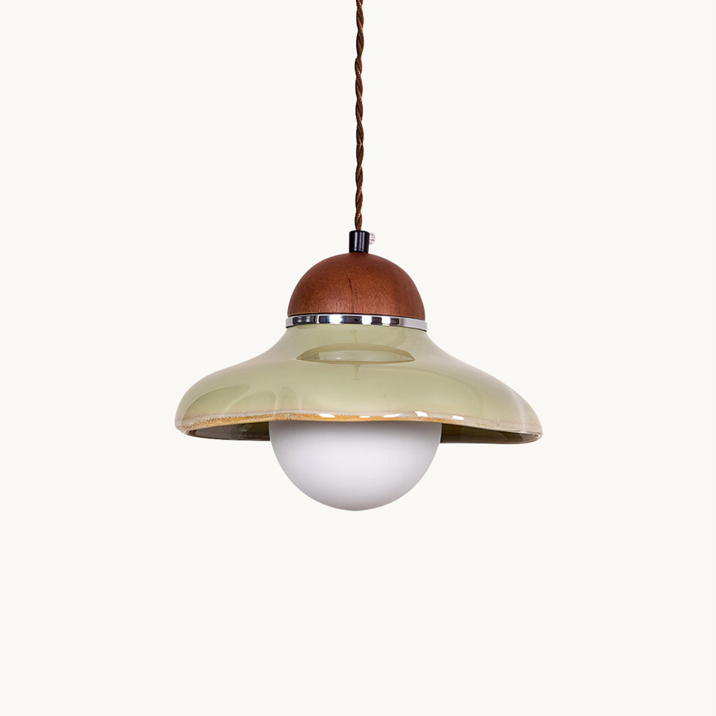 Green ceramic Clérachic dome pendant with a walnut-coloured wooden cap and a round frosted glass globe, on a white backdrop.