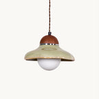 Green ceramic Clérachic dome pendant with a walnut-coloured wooden cap and a round frosted glass globe, on a white backdrop.