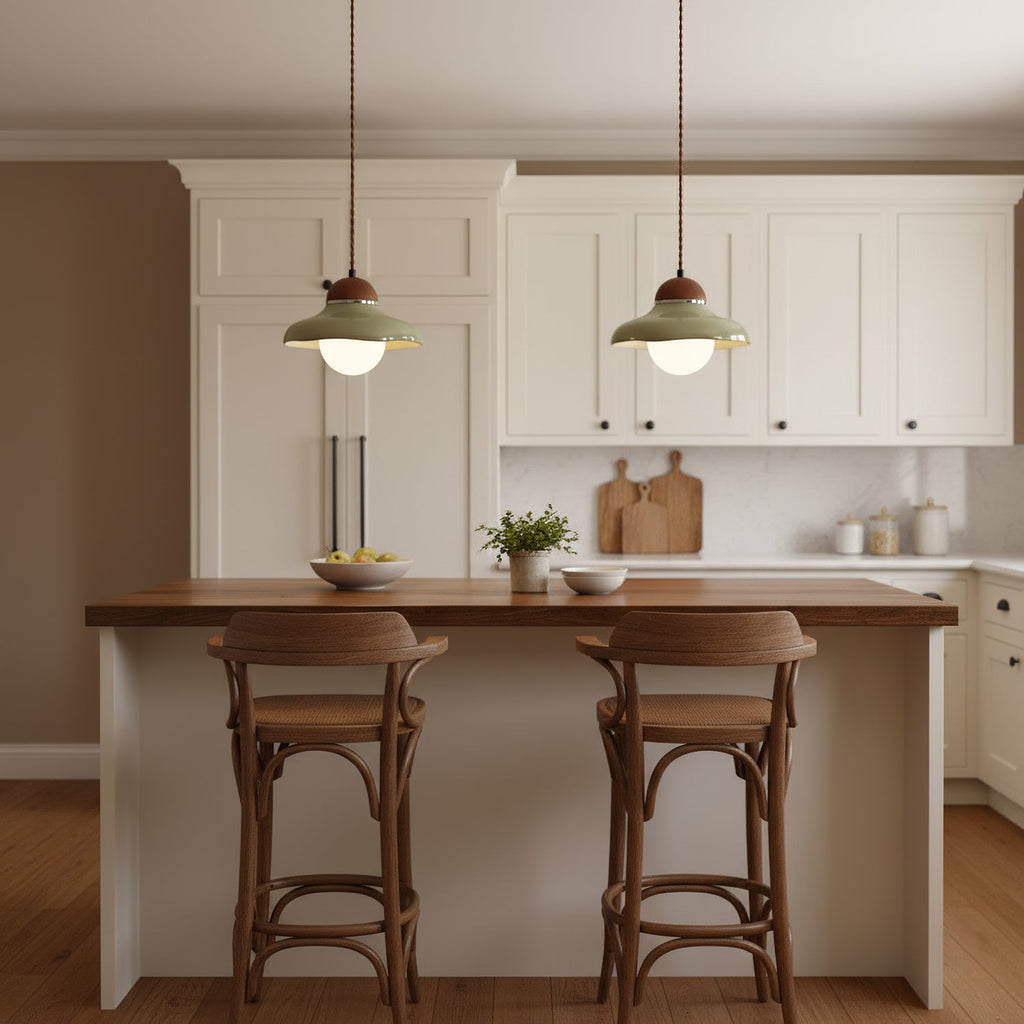 Pair of green ceramic Clérachic pendants over a kitchen island with a walnut top and two wooden stools.