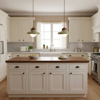 A matched pair of Clérachic green ceramic pendants hang in a cream kitchen, one either side of a window.