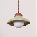 Clérachic green pendant on a twisted brown cord, with a flared ceramic shade and a round white globe below.