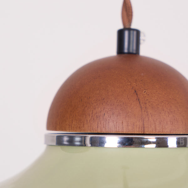 Close view of the grain of the walnut-coloured wooden cap and the silver band above the green ceramic on this Clérachic pendant.