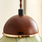 Close view of the wooden dome cap, black cord grip and gold-toned ring on this Clérachic pendant.