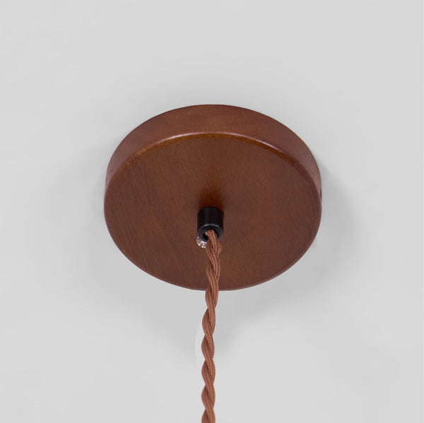 Round walnut-coloured ceiling canopy with a twisted brown cord hanging from it, for this Clérachic pendant.