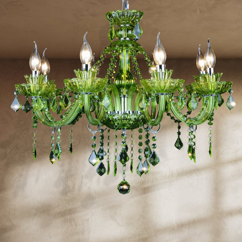 Clérachic green glass chandelier with eight curving candle arms and cascading green crystal drops, hung against a plaster wall.