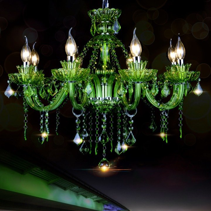 Clérachic eight-arm green glass chandelier with faceted crystal drops and chain swags, glowing against a dark night backdrop.