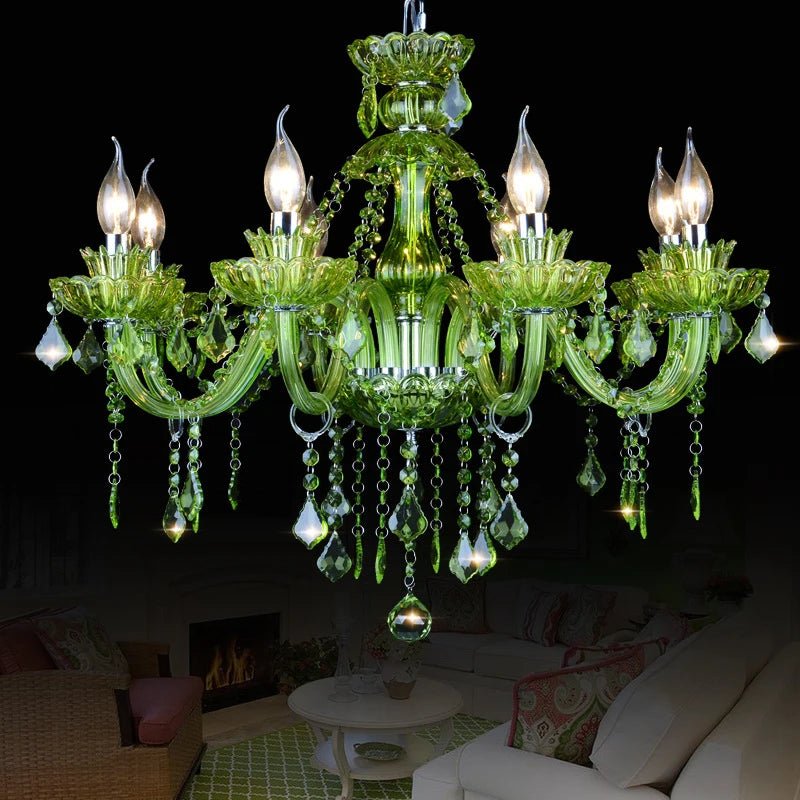 Clérachic eight-arm green glass chandelier with crystal drops, hung over a living room with a lit fireplace and cream sofa.