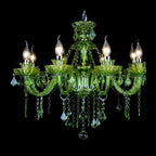 Clérachic eight-arm green glass chandelier with candle bulbs and strings of green crystal, shown lit on a black backdrop.