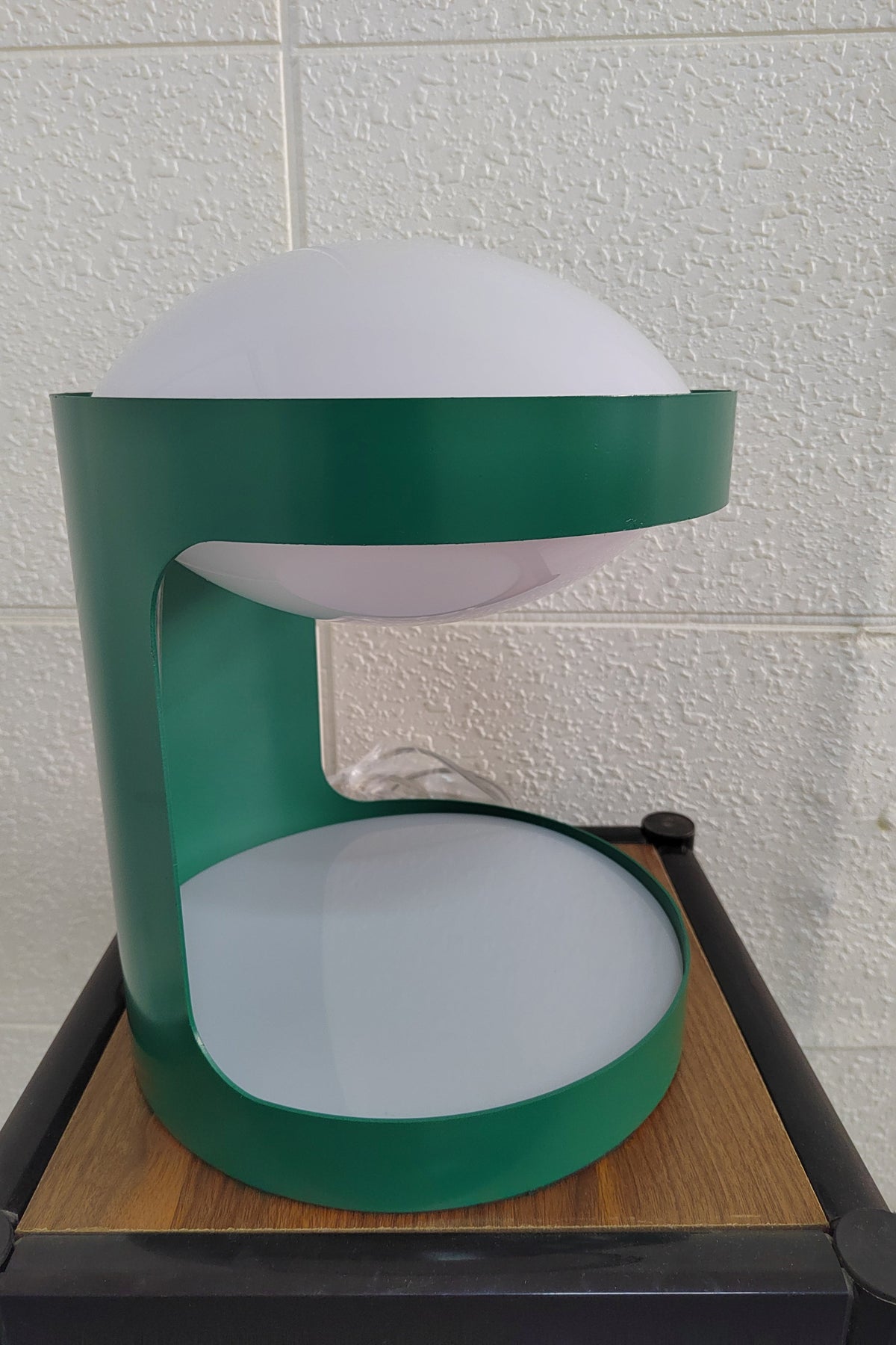 Side view of this Clérachic table lamp in a narrow frame, its green open body and pale dome on a wood-top stand.