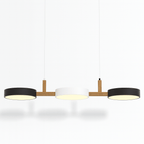 This Clérachic three-light pendant shows dark drum shades either side of a white centre shade, cables bare.