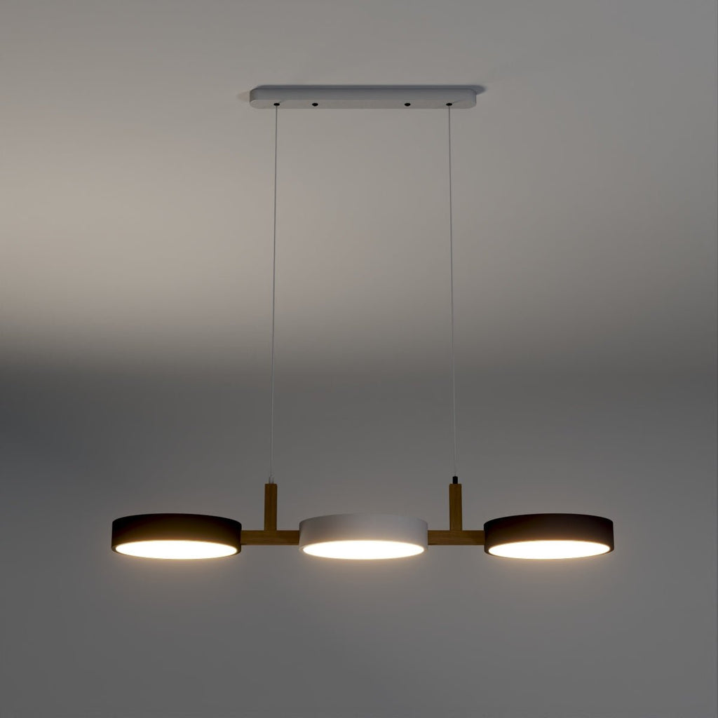Clérachic's three-drum pendant glows warm with dark shades and a white centre disc against a charcoal backdrop.