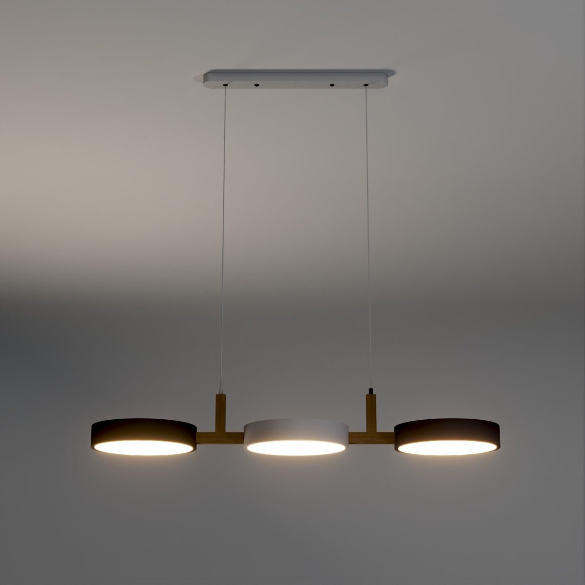 Clérachic's three-drum pendant glows warm with dark shades and a white centre disc against a charcoal backdrop.