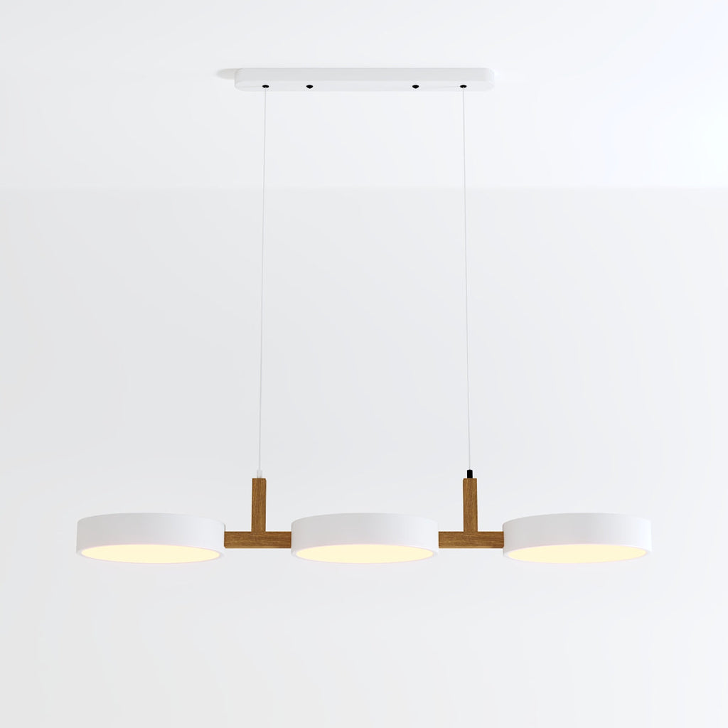 Clérachic's three-light pendant in all-white drum shades hangs lit from a rectangular white ceiling canopy.