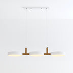 Clérachic's three-light pendant in all-white drum shades hangs lit from a rectangular white ceiling canopy.