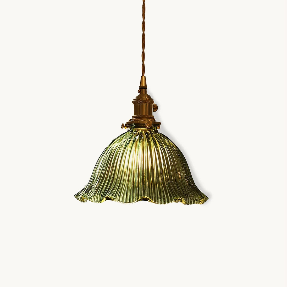 Green ribbed glass pendant with a frilled rim and brass fitting on a twisted cord, shown on a plain white backdrop from Clérachic.