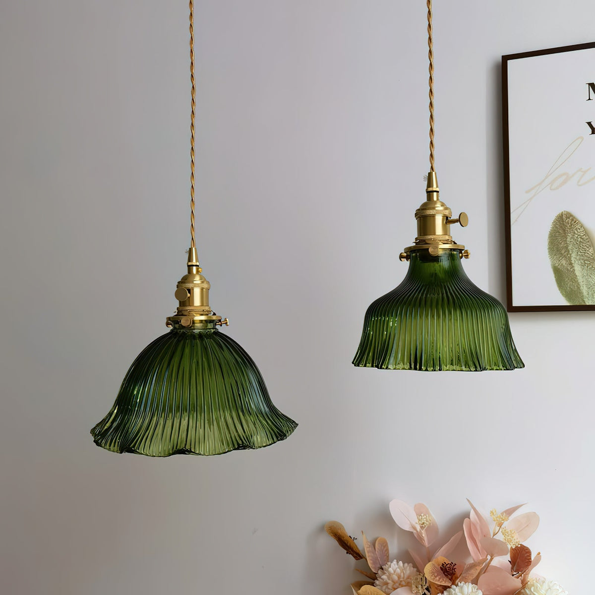 Two darker green ribbed pendants hung together before a pale wall with a framed print, from Clérachic.