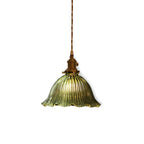 Clérachic green ribbed glass pendant with brass holder and twisted cord, lit on a plain white backdrop.