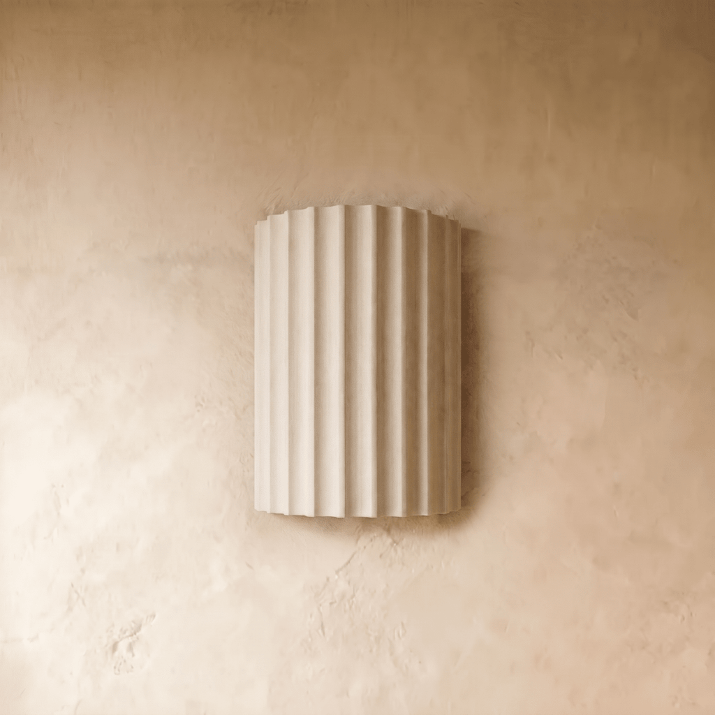 Clérachic wall lamp in white, the fluted half-cylinder shade shown unlit against a textured plaster wall.