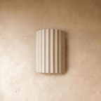 Clérachic wall lamp in white, the fluted half-cylinder shade shown unlit against a textured plaster wall.
