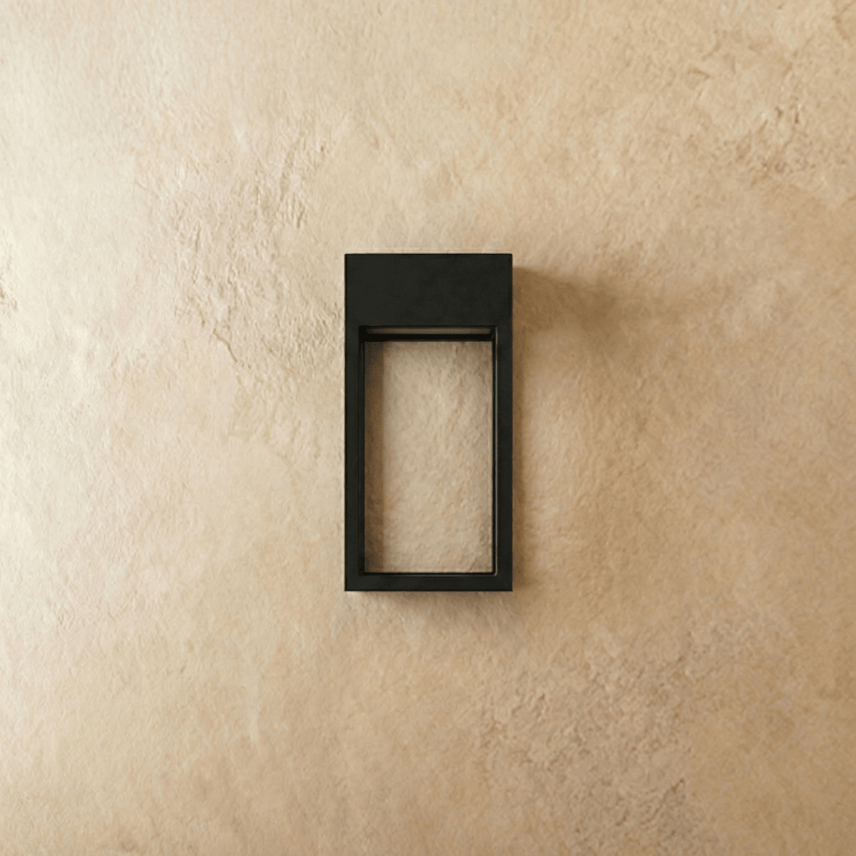 Clérachic grey steel wall sconce shown unlit, its open rectangular frame mounted flush on a plaster wall.