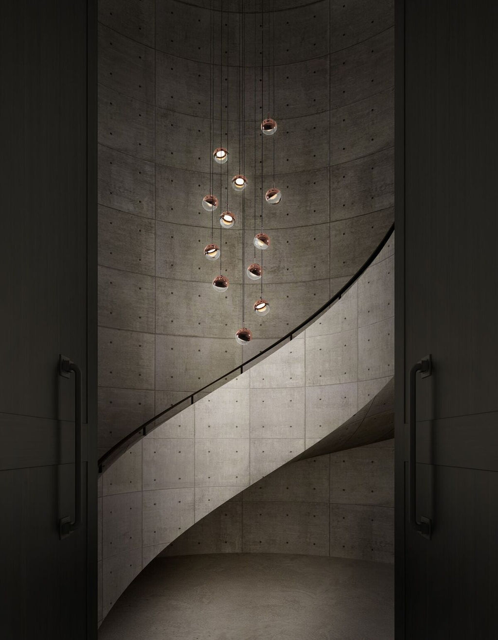 Small Clérachic globe pendants hung at stepped heights down a curved concrete stairwell, with a dark door either side.