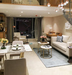 Rose gold Clérachic globe pendants hung from a mezzanine above a living and dining area with a cream sofa.