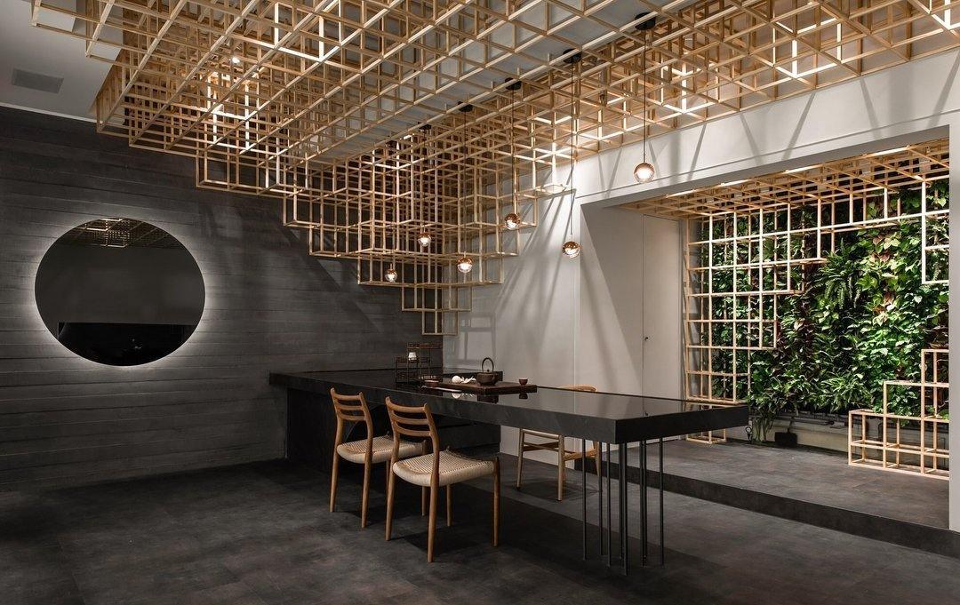 Clérachic globe pendants hung under a timber lattice ceiling, with a round backlit mirror and a green wall beyond.