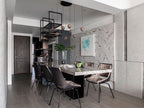 Small Clérachic globe pendants hung in a group over a marble-topped dining table, with leather chairs and a herringbone stone wall.