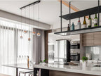 Five small Clérachic globe pendants over a white kitchen island, with a hanging bottle rack and tall windows with sheer curtains.