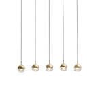Five gold-finish Clérachic globe pendants in a row, each with a clear glass lower half and a lit LED, on a pale grey backdrop.