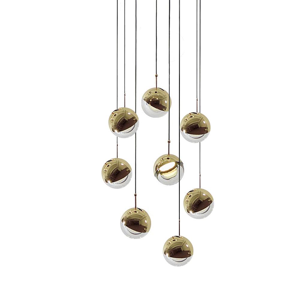Cluster of nine gold-finish Clérachic globe pendants hung close together on cords of varied length, on a white backdrop.