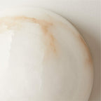 Close-up of the Clérachic Half-Dome Alabaster Wall Sconce rim, rust-toned veins running through the translucent white stone.