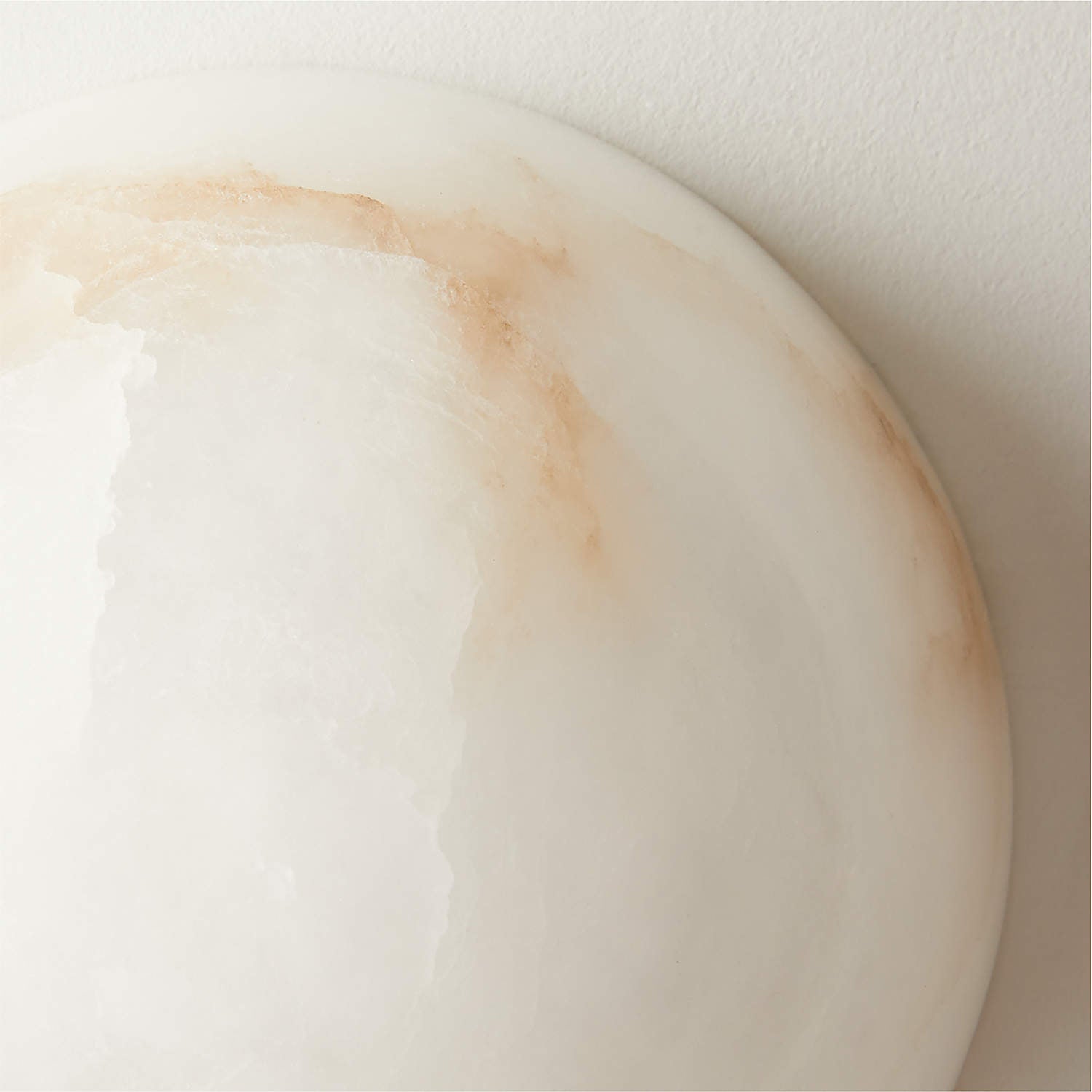 Close-up of the Clérachic Half-Dome Alabaster Wall Sconce rim, rust-toned veins running through the translucent white stone.