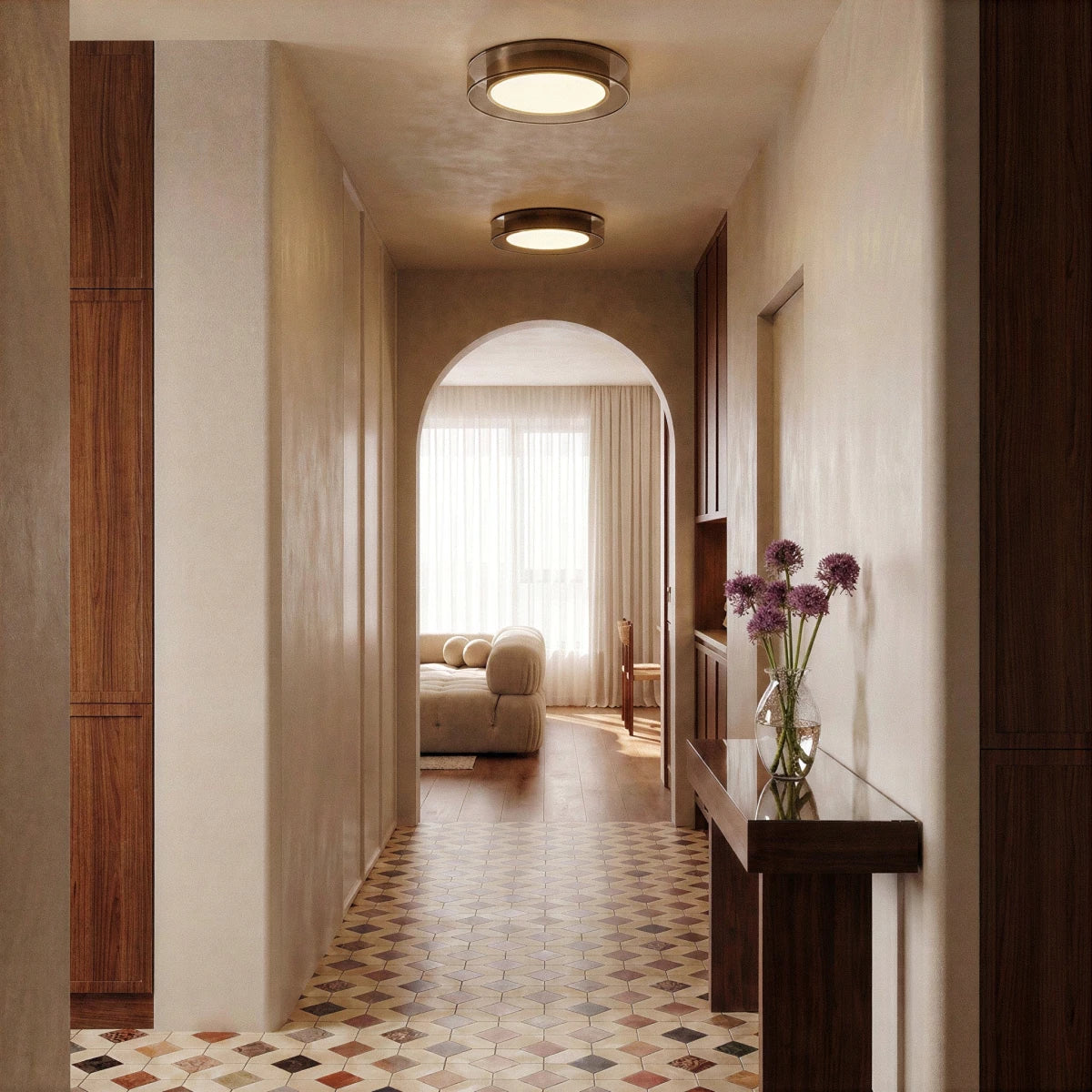 Two Clérachic halo ring ceiling lights glow along a tiled hallway leading through an arch to a sunlit living room.