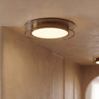 Close view of a Clérachic halo ring ceiling light glowing above a wood-paneled corridor with a second fixture beyond.